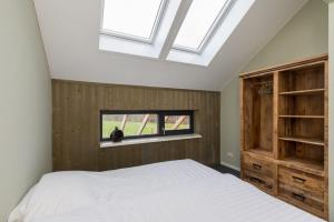 1 dormitorio con cama y ventana en Holidayhome - Vroondijk 2 Vrouwenpolder 'Zeebloesem', en Vrouwenpolder