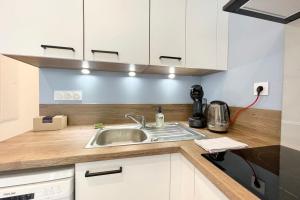 グルノーブルにある#CC Le Cadet Jean Jaurès A B and E tramway T2 equippedの白いキャビネットとシンクのあるキッチン +7枚の写真