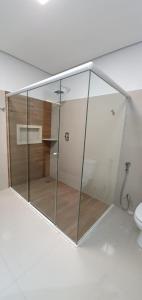 a bathroom with a shower, toilet and sink at Hotel Cancioneiro in Sinop