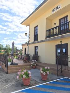 a house with a balcony and a patio area at Hotel Salldemar in Santillana del Mar