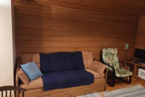 ein Sofa und ein Stuhl im Wohnzimmer in der Unterkunft Holiday Cabin Kerimaa 103 in Savonlinna