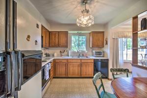 a kitchen with wooden cabinets and a table and a refrigerator at Harrisburg Home with Deck 12 Mi to Hersheypark in Harrisburg