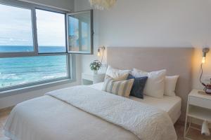 a bedroom with a bed with a view of the ocean at Apt ILUKA Nuevo con vistas al mar in Malpica