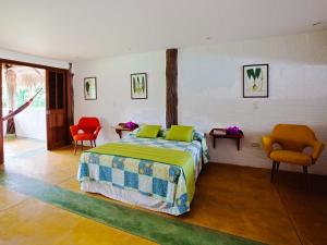 a bedroom with a bed and two chairs at Hotel Cinaruco Caney in Villavicencio