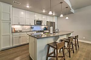 een keuken met witte kasten en een eiland met barkrukken bij Fort Collins Townhome Remote Workers Welcome in Fort Collins