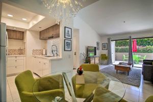 a kitchen and living room with a glass table and green chairs at Classic-Yet-Modern Abode by Downtown Palm Springs! in Palm Springs