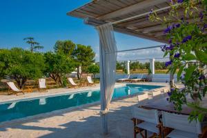 una piscina con pergolato, tavolo e sedie di Masseria Villa Gioia a Corato