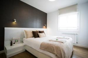 ein Schlafzimmer mit einem großen weißen Bett und einem Fenster in der Unterkunft Butrón - Basquenjoy in Hondarribia