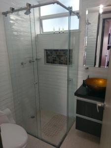 a bathroom with a glass shower with a sink and a toilet at MIRADOR TUNJA 401 in Tunja
