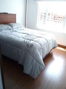 a bed in a bedroom with a large window at La Bendición Tunja 401 in Tunja