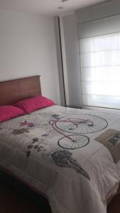 a bedroom with a bed with a painting on it at MIRADOR TUNJA 401 in Tunja