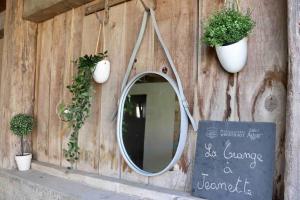 伯恩霍普勒豪特的住宿－La grange de Jeanette，木墙上带有植物和标志的镜子