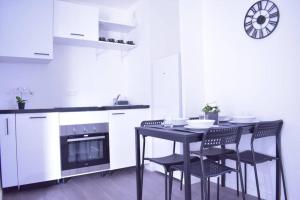 y cocina con mesa, sillas y fogones. en Hébergement touristique de luxe proche de Paris avec parking gratuit, situé face au parc des expositions et de l'aéroport du Bourget, à 15 min de CDG, en Le Blanc-Mesnil