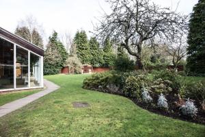 a garden with a lawn and trees and a building at voco St. Johns Solihull by IHG in Solihull