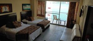 Suite en torres gemelas con vista al mar في أكابولكو: غرفة فندقية بسريرين وبلكونة
