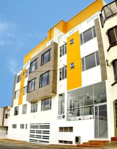 a tall building with yellow and white at La Bendición Tunja 401 in Tunja