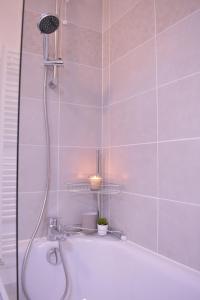 a bathroom with a bath tub with a candle at Hébergement touristique de luxe proche de Paris avec parking gratuit, situé face au parc des expositions et de l'aéroport du Bourget, à 15 min de CDG in Le Blanc-Mesnil
