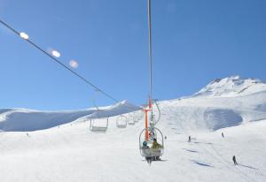 a ski lift with people on it in the snow at Hotel Alto Nevados in Nevados de Chillan