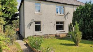 a house with a garden in front of it at Lovely self-catering apartment in city centre in Dumfries