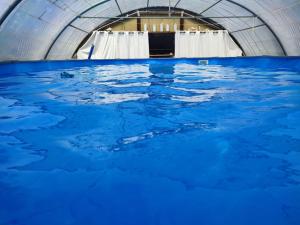 ein Pool mit blauem Wasser in einem Gebäude in der Unterkunft Les Geais 