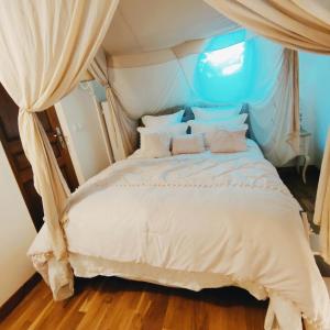 a bedroom with a white bed with a canopy at Au cheval blanc in Gommegnies