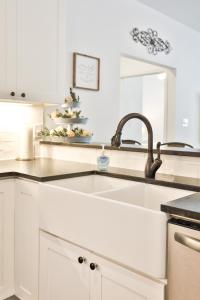 a white kitchen with a sink and a mirror at Hill Country Haven a Modern Rustic - 2 Bedroom 2 Bathroom Townhouse off Main Street in Fredericksburg