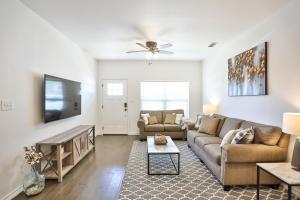 a living room with a couch and a tv at Hill Country Haven a Modern Rustic - 2 Bedroom 2 Bathroom Townhouse off Main Street in Fredericksburg