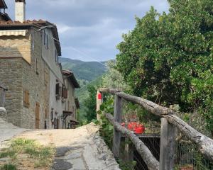 a wooden fence next to a building and a mountain at Casa Tasso in Reggello