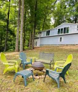 um grupo de cadeiras e uma fogueira em frente a uma casa em Paradise View Getaway-Dacha em Hartwell