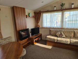 a living room with a couch and a television at 8 Berth on Coastfields Ingoldmells (Vacation) in Ingoldmells
