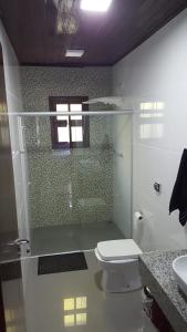 ein Badezimmer mit Toilette und Glasdusche in der Unterkunft Casa praia fortaleza pé na areia in Ubatuba + 30 Fotos