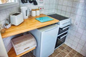 a small kitchen with a wooden counter top and a sink at Apartment 1 Large Studio Sea Front- Sea Views- Free Parking in Paignton