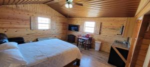 Stateline Cabin في هوبز: غرفة نوم بسرير في غرفة خشبية