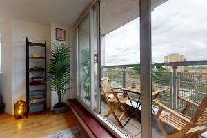 a room with a balcony with a table and chairs at Cozy Hackney Apartment in London