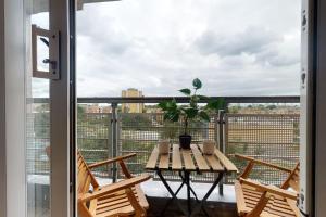 a table with a potted plant on a balcony at Cozy Hackney Apartment in London