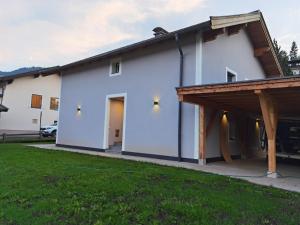 a white house with a porch and a garage at Ferienhaus Esila in Fieberbrunn