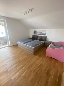 a bedroom with a bed and a wooden floor at Ferienhaus Esila in Fieberbrunn