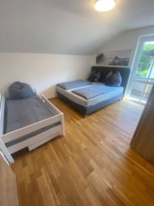 two beds in a room with wooden floors at Ferienhaus Esila in Fieberbrunn +2 photos
