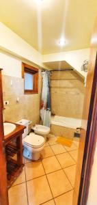 La salle de bains est pourvue de toilettes, d'un lavabo et d'une baignoire. dans l'établissement Ushuhouse Apartments, à Ushuaia