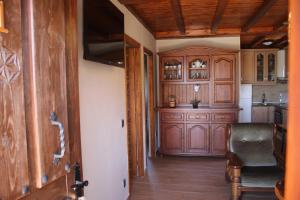 una cocina con armarios de madera y una silla en una habitación en Les Casines, en Luanco