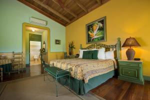 a bedroom with a bed, a chair, and a painting on the wall at Hotel Casa Turire in Turrialba