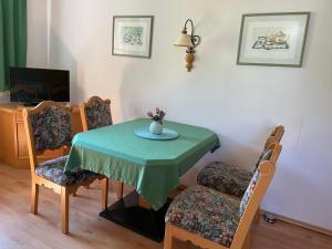- une table à manger avec une table et des chaises vertes dans l'établissement Ferienhaus Alpenblick, à Krakauschatten