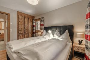 ein Schlafzimmer mit einem großen Bett mit weißer Bettwäsche in der Unterkunft Alpslodge - Napa in Arosa