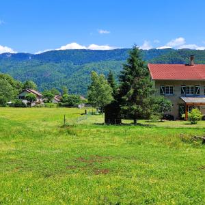 une maison dans un champ avec des montagnes en arrière-plan dans l'établissement Les Lodges Du Pavillon F3, à Molinges