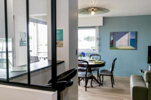 een eetkamer en een woonkamer met een tafel en stoelen bij Appartement Front de Mer à Carnac Plage in Carnac