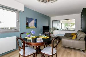 un salon avec une table, des chaises et un canapé dans l'établissement Appartement Front de Mer à Carnac Plage, à Carnac