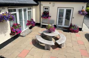a patio with two benches and flowers in front of a house at Private Room with Private Entrance. in Galway