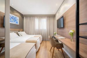 a hotel room with two beds and a desk at Intercity Sao Leopoldo in São Leopoldo +25 photos