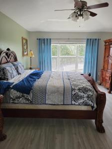 a bedroom with a bed with blue curtains and a window at Newly renovated Windsor Hills residential home in Orlando