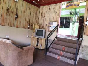 sala de estar con TV y escalera en Hospedaje Lolita, en San Pedro La Laguna